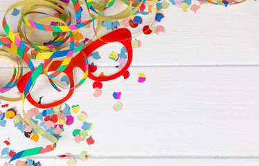 carnival party background with confetti, streamer and glasses