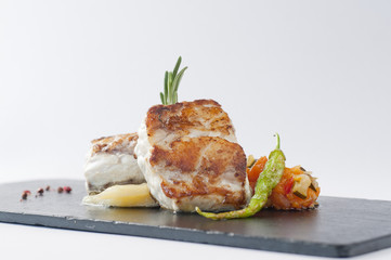 Mero al horno sobre pisto de calabaza.