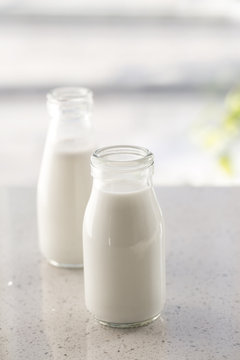 Two bottles of milk on table