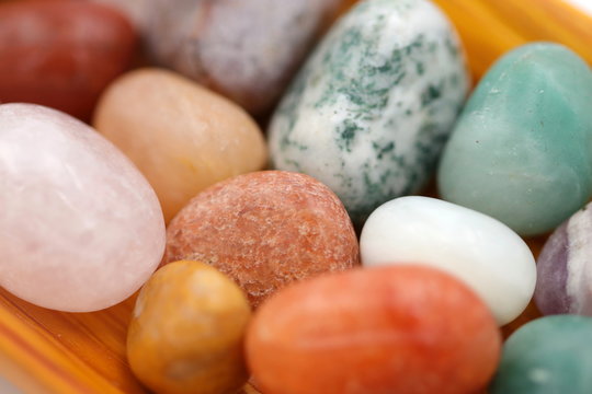 Detailaufnahme eines orangefarbenen Jaspis inmitten anderer Heilsteine