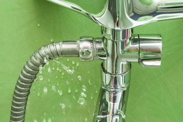 Damaged leaking water tap hose in the bathroom of house, flat or other place. Plumbing concept.