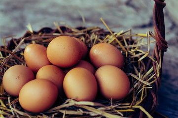Close up of eggs in a dark brown basket.Top view of brown eggs in wooden basket.Hen eggs basket.