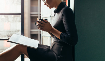 Woman reading magazine with coffee