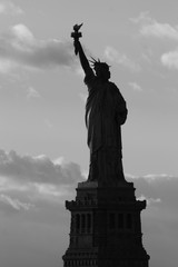 Silhouette of statue of Liberty in New York City at sunset - black and white