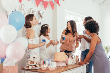 Pregnant woman celebrating baby shower party with friends - obrazy, fototapety, plakaty