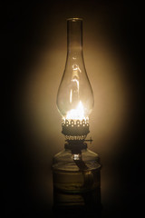 Glowing antique old kerosene oil lamp with vintage glass chimney