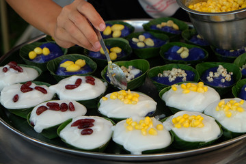 Making of big Thai pudding dessert with toppings over coconut milk