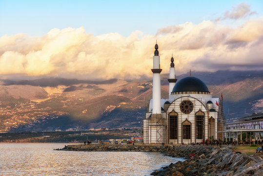 Mountain and embankment in Iskenderun port on the sunset. Winter, January. View to the mosque.