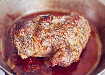 Roasted pork steak in frying pan.