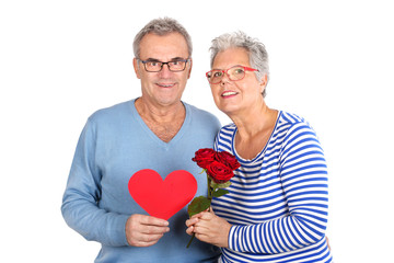 glückliches Seniorenpaar mit Herz und Rosen