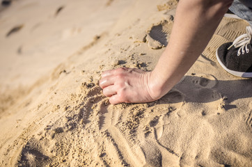 A female hand with sand. Woman pouring sand