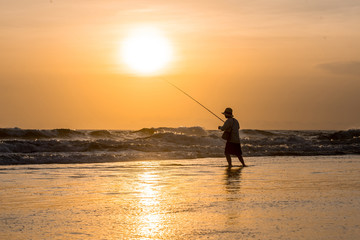 Man fishing in the evening at beach