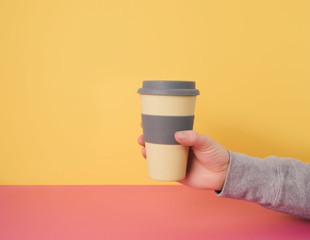 Hand holding take away coffee cup.