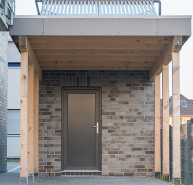 Moderner Carport mit Tür in anthrazit und Solaranlage