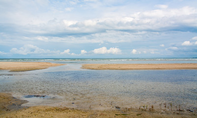 The sea shore stranded the spit, waves, landscape and blue sky with white clouds