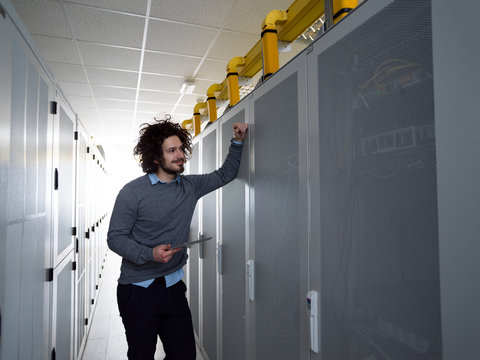 IT engineer working on a tablet computer in server room