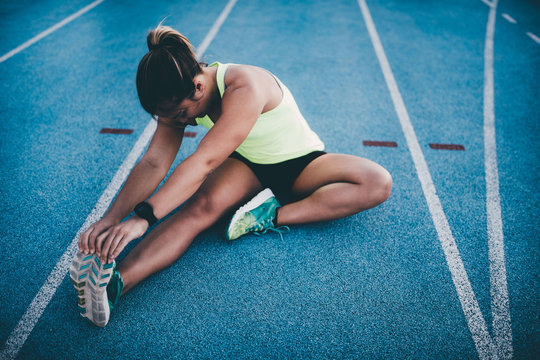 Female athletic woman stretching after running workout