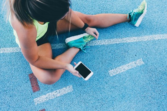 Female athlete using phone to track workout