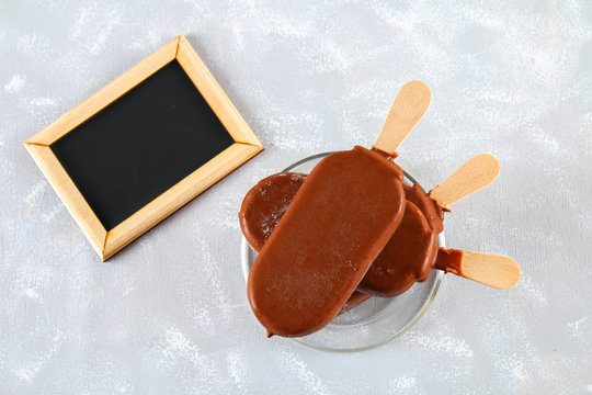 Ice cream eskimo pie on a stick with a copy space for text on a gray background. Concept for the holiday International Eskimo pie day.