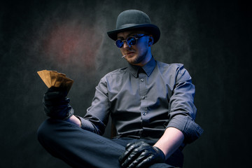 A man in gloves and black glasses plays cards in gambling