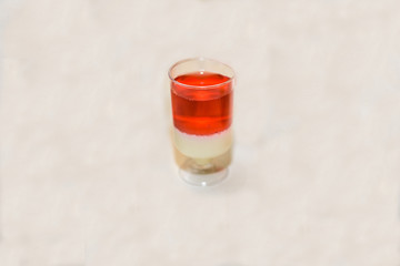 one glass with red drink alcohol on white backdrop