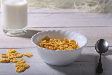 Corn Flakes cereal in a bowl and glass with milk. Morning breakfast.