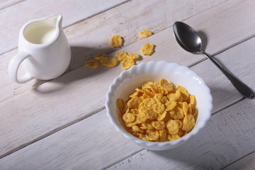 Corn Flakes cereal in a bowl and glass with milk. Morning breakfast.