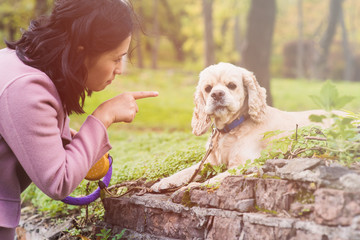 Asian woman training her dog in park