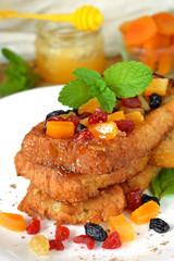 Toasts made of white bread with dried fruits and mint topping. Breakfast meal