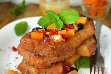 Toasts made of white bread with dried fruits and mint topping. Breakfast meal
