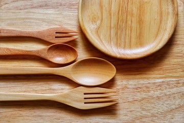Top view, Wooden spoons, forks and wooden plate or dish on the wooden table