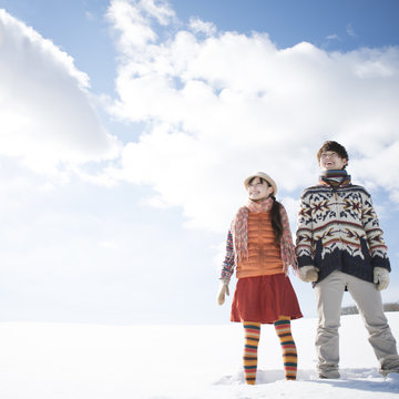 雪原に立ち微笑むカップル