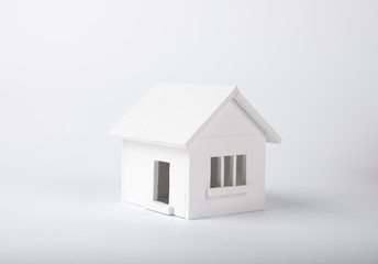 house in winter - heating system concept and cold snowy weather with model of a house wearing a knitted cap