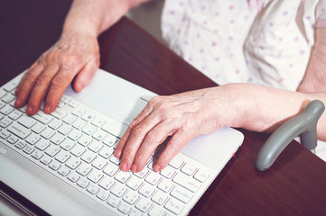 Fototapeta na wymiar Old woman's hands and laptop.