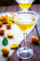 cocktail with kumquat on wooden background