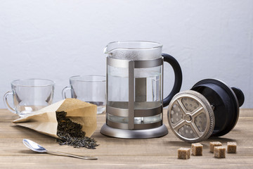 Kettle French press and tea on a wooden table