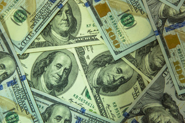 One hundred dollars pile as background.