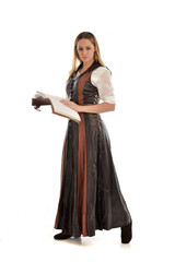 Fototapeta premium full length portrait of girl wearing brown fantasy costume, holding a book. standing pose on white studio background. 