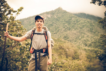 A portrait of a Handsome young trekking on an uphill. nature background. Asia people. Vintage or retro tone.