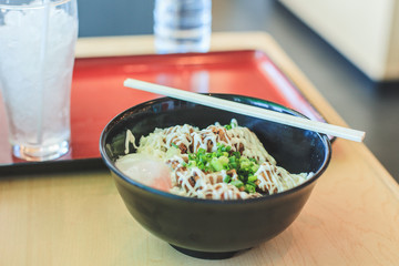 Rice with Teriyaki chicken rice and poached egg (Onsen egg), mayonnaise and coriander on top in the bowl and chopstick , Japanese food in the resturant 