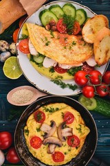 A set of omelets with vegetables, mushrooms and chicken. On a wooden background. Top view. Copy space.
