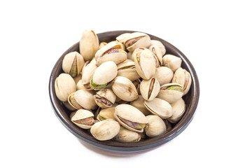 Closeup of some roasted pistachio in bowl over white background