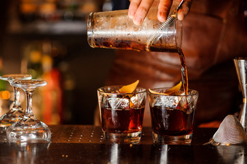 Barman versant une boisson alcoolisée dans les verres
