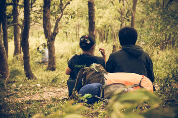 Couple young sitting on an uphill of trekking . nature background. Asia people. Vintage or retro...