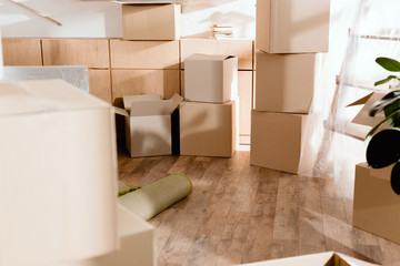 rolled carpet and cardboard boxes in new apartment, moving concept