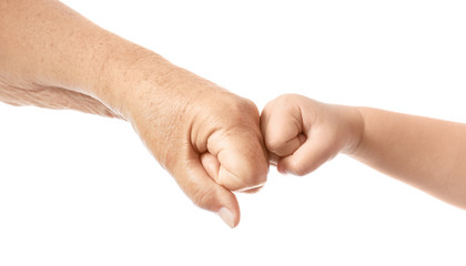 Fists of elderly man and child on white background