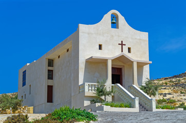 Fototapeta na wymiar St Anne catholic chapel against clear blue sky. This chapel is located near Dwejra in San Lawrenz on the island Gozo on Malta.
