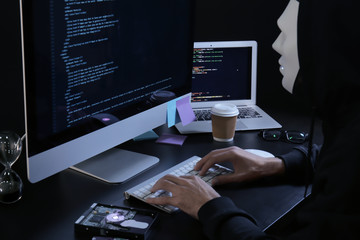 Masked man hacking server in dark room
