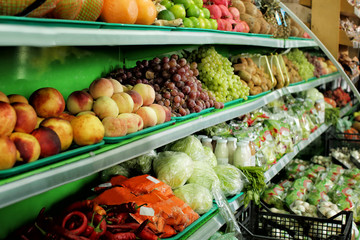 Variety of different fruits and vegetables on shelves in supermarket