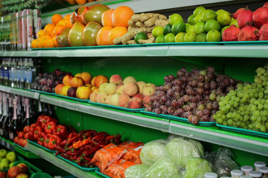 Variety of different fruits and vegetables on shelves in supermarket